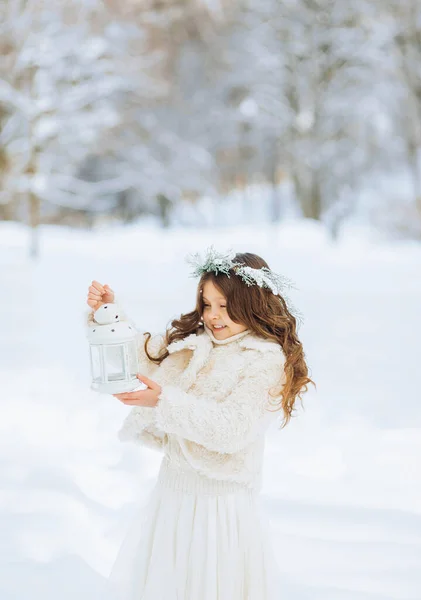 小さな女の子は雪を楽しんでいます 手にクリスマスの提灯を持った花輪の少女 クリスマスの背景 — ストック写真