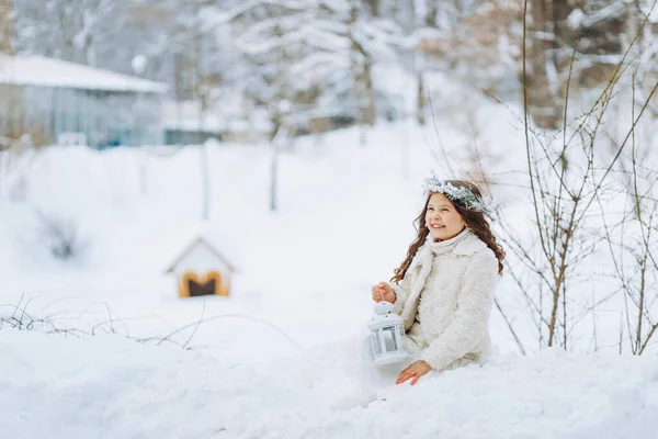 Mała Urocza Dziewczynka Świątecznym Wieńcu Siedząca Śniegu Latarnią Rękach — Zdjęcie stockowe