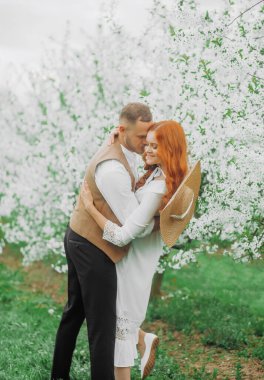 Romantizm, insanlar, aşk ve flört kavramı. Kiraz çiçekleri eşliğinde mutlu bir çift. Bahar