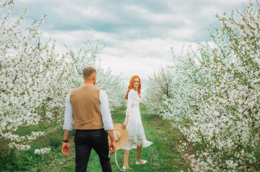 Aşık bahar çifti. Bahar Parkı 'nda yürüyen ve güzel bahar çiçeklerinin tadını çıkaran çift..