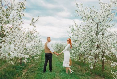 Aşık bahar çifti. Bahar Parkı 'nda yürüyen ve güzel bahar çiçeklerinin tadını çıkaran çift..