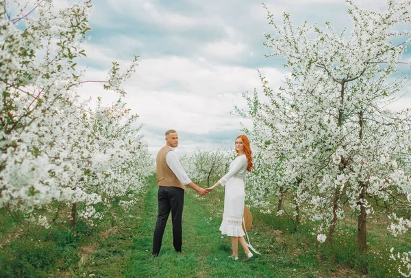 Spring couple in love. Couple in live walking in the spring Park and enjoying the beautiful spring blossom nature.