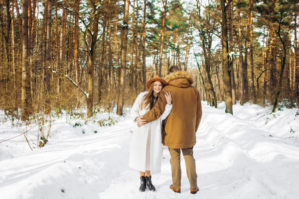 Aile kışın çam ormanında bir köpekle yürüyüşe çıkar..