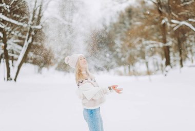 Pembe ceketli kadın kış tatilinde havaya kar fırlatıyor. Mesaj için yer, afiş. Noel, Yeni Yıl.