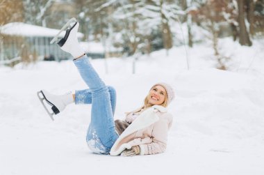 Genç bir kadın kış parkındaki buz pateni pistinde karda poz veriyor..