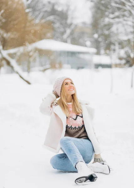 Schöne Frau Sitzt Auf Dem Frostigen Schnee Einem Winterpark Schlittschuhen — Stockfoto