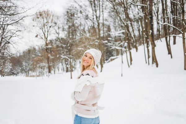一个穿着羊毛衫的漂亮姑娘正在享受冬季时光的特写 在户外拍摄的照片中 一位头戴粉色帽子的短发女士在一个雪天的早晨在模糊的自然背景下玩乐 — 图库照片