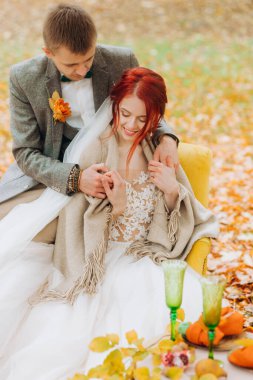 Koca, güz parkında gelini eşarpla örtüyor..