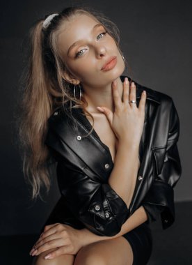 Siyah bluzlu güzel sarışın bir kadının stüdyo portresini kapat, yan tarafa bakıyor. Mavi gözler, genç ve narin.