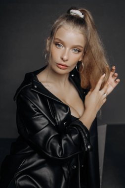 Siyah bluzlu güzel sarışın bir kadının stüdyo portresini kapat, yan tarafa bakıyor. Mavi gözler, genç ve narin.