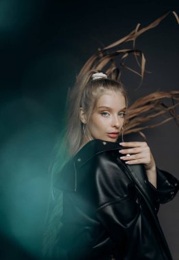 Gri arka planda seksi bir sarışının portresi. Arkaplanda turkuaz bulanıklık etkisi.