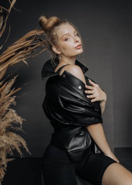 Seksi siyah elbiseli güzel bir genç kadın. otururken