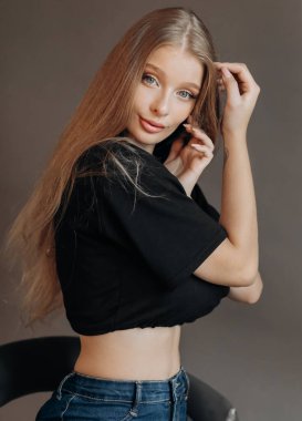 Siyah bluzlu, sevimli sarışın bir kadının stüdyo portresini kapat. Mavi gözler, genç ve narin.