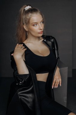 Gri arka planda sarışın kadın modelin minimalist portresi. şık kıyafetler, siyah klasik tarz konsept.