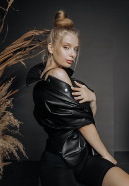 Seksi siyah elbiseli güzel bir genç kadın. otururken