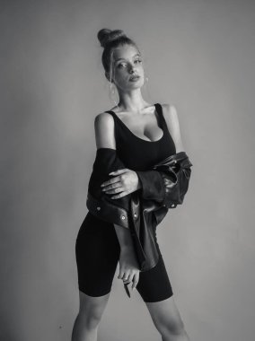 Siyah bluzlu ve turkuaz arka planda poz veren güzel bir kız.