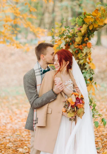 Düğün kemerinin yanındaki parkta genç bir çiftin şefkati ve kucaklaması..