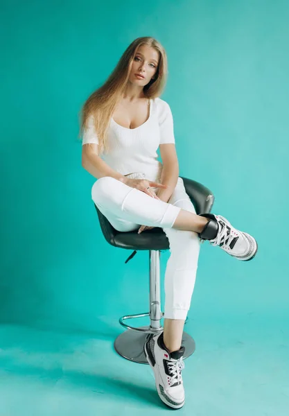 Menina Bonita Terno Branco Sentado Uma Cadeira Estúdio Fundo Turquesa — Fotografia de Stock