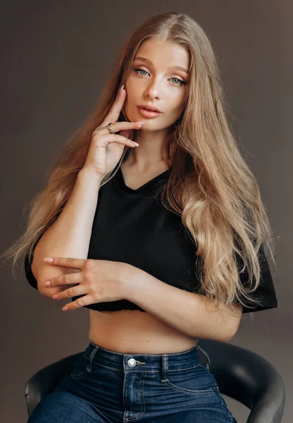 Siyah bluzlu güzel sarışın bir kadının stüdyo portresini kapat. Mavi gözler, genç ve narin.