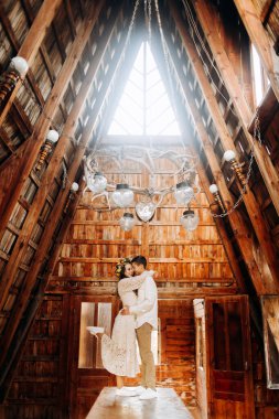 Genç çift, sıcak ahşap binanın içinde masanın üzerinde duruyor.