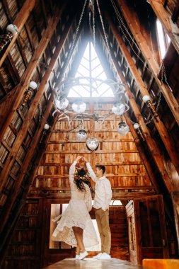 Genç çift, sıcak ahşap binanın içinde masanın üzerinde duruyor.