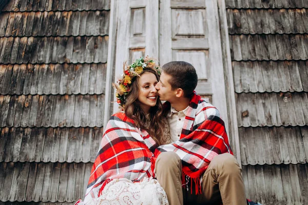 Casal Jovem Coberto Com Cobertor Beijando Frente Uma Fabulosa Casa — Fotografia de Stock