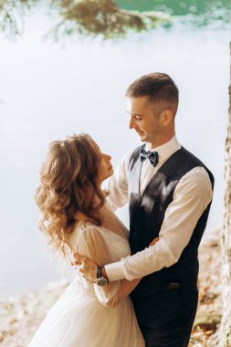 Güneşli bir günde, dağ gölünün yanında genç bir çift..