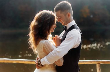 Gelin ve damat dağlardaki gölün yanında. Bir çift, bir dağ manzarasının arka planına karşı.