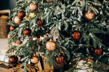 Kış tatili kompozisyonu olarak kahverengi toplarla süslenmiş modern tasarım Noel ağacı. Kapat.