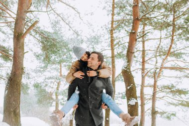 Karla kaplı genç bir çift parkta yürüyor. Kış yürüyüşü