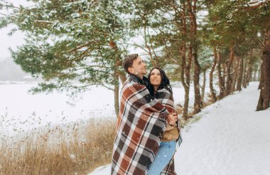 Karla kaplı genç bir çift parkta yürüyor. Kış yürüyüşü