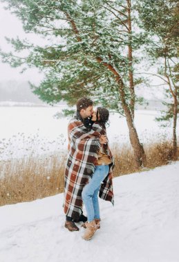 Karla kaplı genç bir çift parkta yürüyor. Kış yürüyüşü