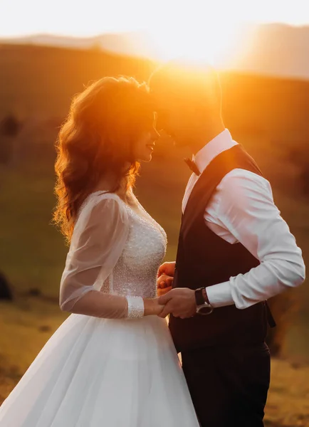 Krásní Novomanželé Stojí Čelem Sobě Drží Ruce Pozadí Západu Slunce — Stock fotografie