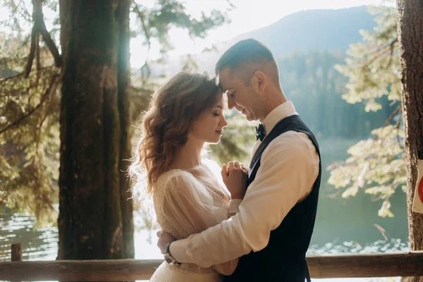 Turkuaz gölün arka planında genç bir çiftin portresi. Kapat.