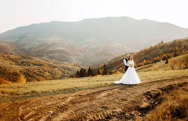 Milující Pár Svatba Novomanželé Bílých Šatech Oblek Procházky Horském Pozadí — Stock fotografie