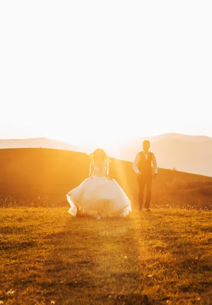Recém Casados Apaixonados Correm Numa Colina Pôr Sol — Fotografia de Stock
