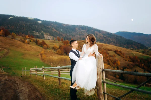 Recém Casados Apaixonados Ficam Perto Uma Cerca Madeira Montanhas Outono — Fotografia de Stock