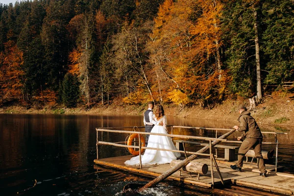 Gelin ve damat dağlardaki gölün yanında. Bir çift, bir dağ manzarasının arka planına karşı.