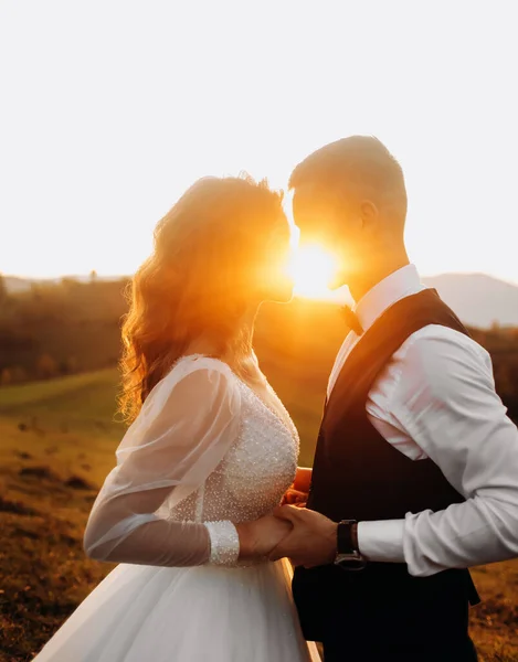 Mladí Novomanželé Stojí Čelem Sobě Drží Ruce Pozadí Západu Slunce — Stock fotografie