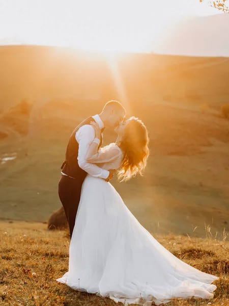 Úžasné Novomanželé Polibek Vrcholu Hory Při Západu Slunce — Stock fotografie