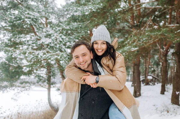 Kille Rider Sin Flickvän Ryggen När Han Går Snöig Skog — Stockfoto