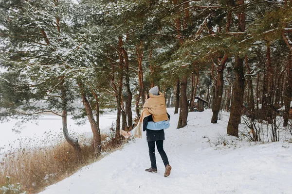Bir Adam Karlı Bir Ormanda Yürürken Kız Arkadaşını Sırtında Taşıyor — Stok fotoğraf