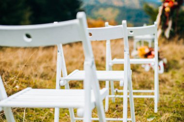 Düğün töreni. Kırsal tarzda beyaz sandalyeler.