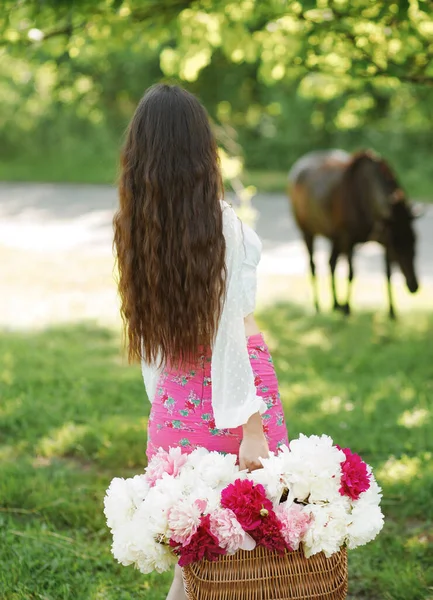 Impresionante Morena Caminando Jardín Sosteniendo Una Canasta Peonías Sobre Fondo —  Fotos de Stock