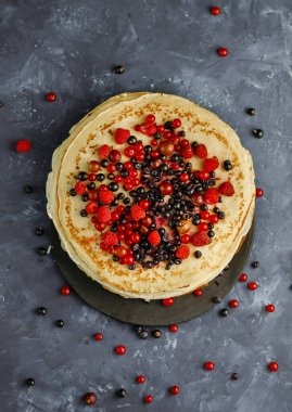 Böğürtlenli krep. Tabağında böğürtlen olan bir yığın ev yapımı krep. Üst görünüm.