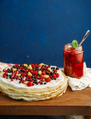 Taze reçelli ev yapımı gözleme ve mavi kırsal masada böğürtlen. Üst manzara, düz yatak, seçici odaklanma. Ülke usulü organik kahvaltı.
