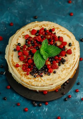 Böğürtlenli krep. Tabağında böğürtlen olan bir yığın ev yapımı krep. Üst görünüm.