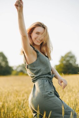 Gün batımında elinde buğday sapıyla muhteşem bir sarışın..