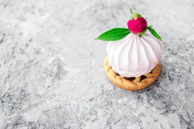 Tatlı. Çiçekle süslenmiş pembe şekerlemeler. Gri arkaplan.