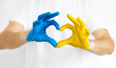 Ukrayna kavramına bayılıyorum. Kalp şeklinde eller Ukrayna bayrağı renginde boyanır - sarı ve mavi. Seçici odaklanma. Ukrayna Bağımsızlık Günü, bayrak